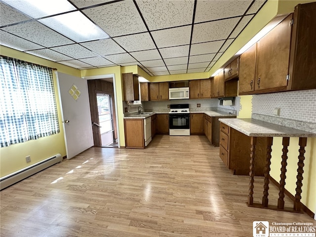 kitchen with white appliances, light hardwood / wood-style floors, plenty of natural light, and sink