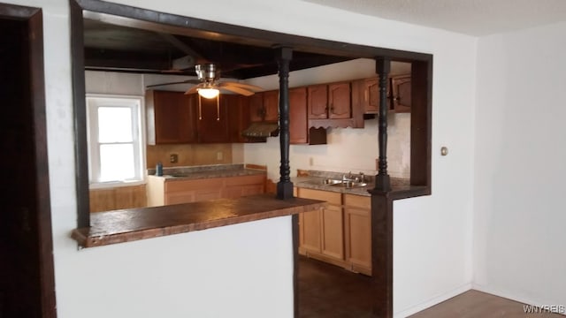 kitchen with ceiling fan, sink, beam ceiling, exhaust hood, and dark hardwood / wood-style floors