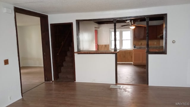 spare room featuring a textured ceiling, ceiling fan, and dark hardwood / wood-style flooring