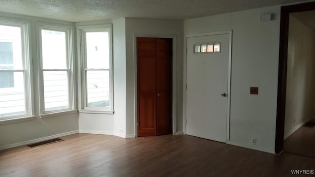 foyer with wood-type flooring and a textured ceiling