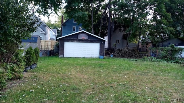 view of yard with a garage and an outbuilding