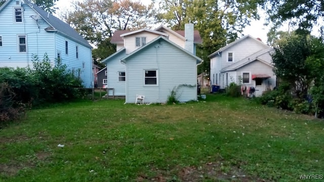 rear view of property with a lawn