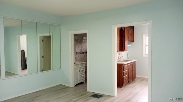 interior space with sink, ensuite bath, and light hardwood / wood-style floors