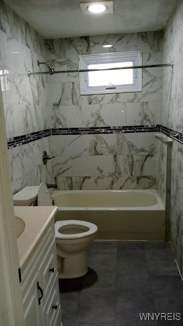 full bathroom with vanity, tiled shower / bath combo, and toilet