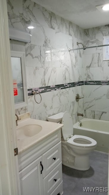 full bathroom featuring tiled shower / bath, vanity, tile walls, and toilet