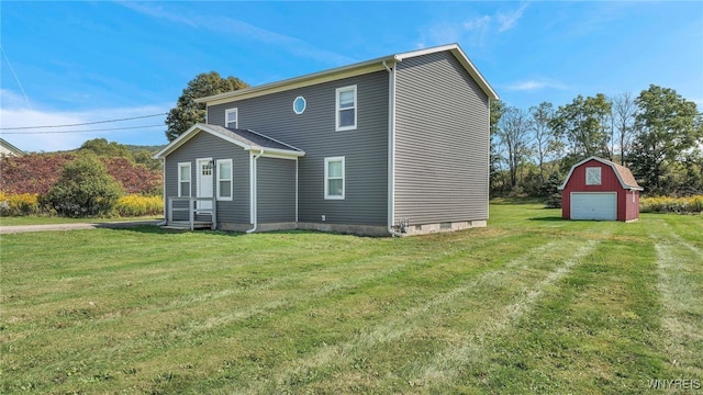 back of house featuring a yard, a garage, and an outdoor structure