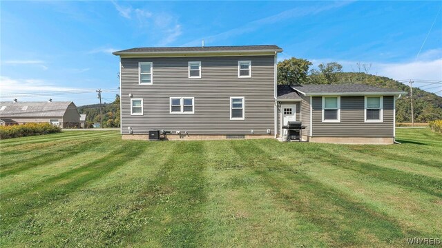 rear view of house with a yard and central air condition unit