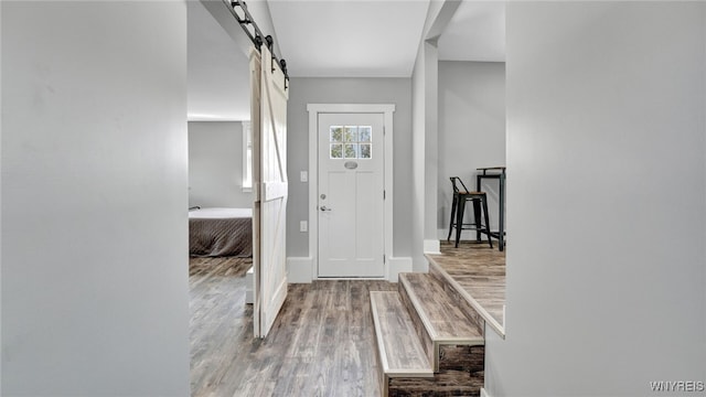 foyer entrance with hardwood / wood-style floors and a barn door