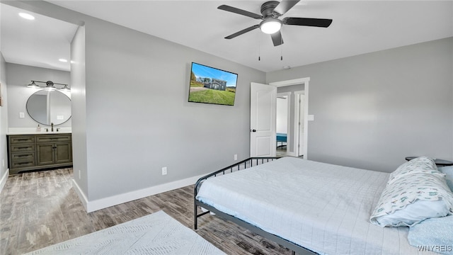 bedroom featuring ceiling fan, light hardwood / wood-style floors, and ensuite bathroom