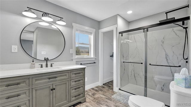 bathroom with vanity, hardwood / wood-style flooring, toilet, and an enclosed shower