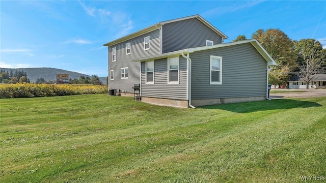 rear view of house featuring a mountain view and a yard