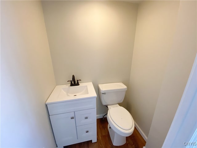 bathroom featuring wood-type flooring, vanity, and toilet