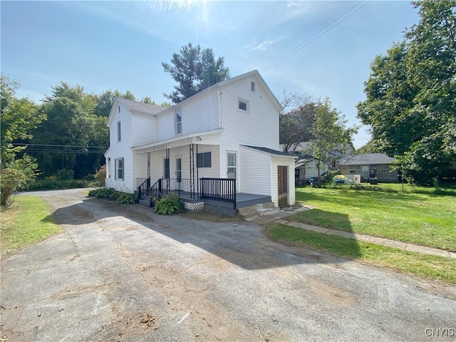 view of side of home with a porch and a lawn