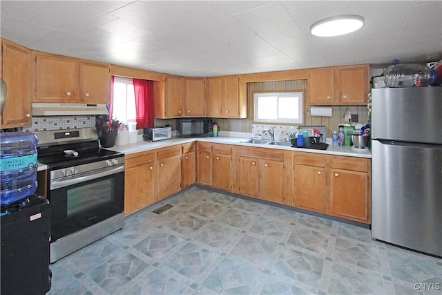 kitchen featuring decorative backsplash, a wealth of natural light, appliances with stainless steel finishes, and sink