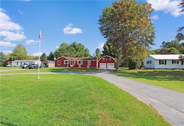 view of front of house with a garage, a front yard, and an outbuilding