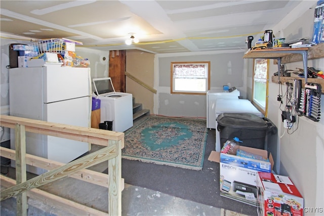 garage with white fridge and washing machine and clothes dryer