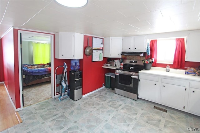 kitchen with white cabinets, light floors, stainless steel electric range, light countertops, and under cabinet range hood