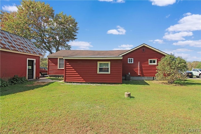 rear view of house with a yard and central AC unit