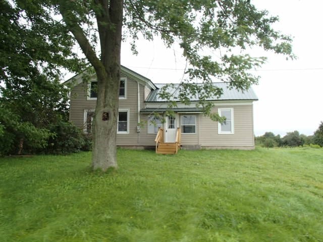 rear view of house featuring a yard