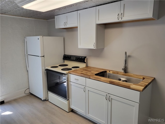 kitchen with white cabinets, white appliances, wooden counters, light hardwood / wood-style flooring, and sink