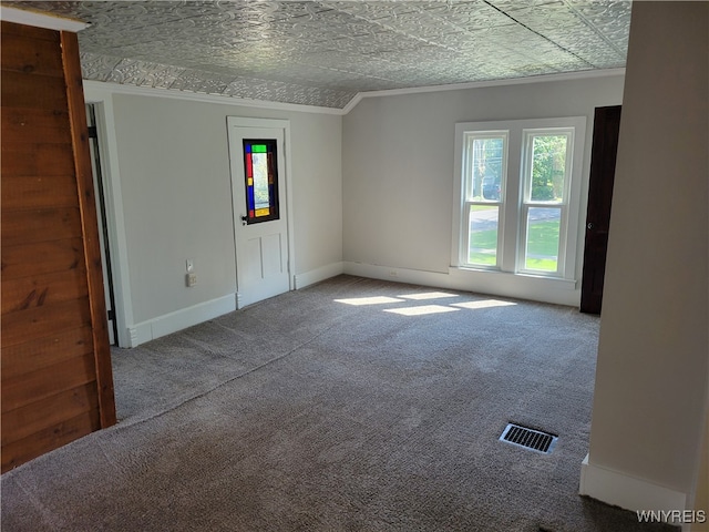 spare room featuring a textured ceiling, carpet floors, and crown molding