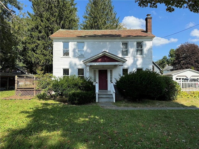 colonial inspired home featuring a front lawn