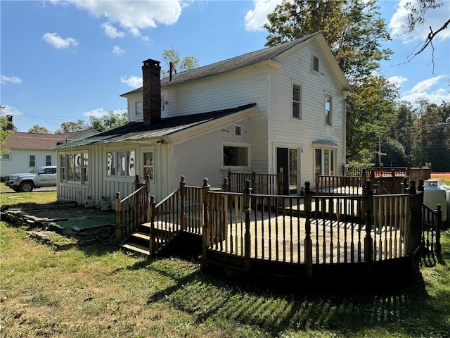 rear view of property with a deck and a yard