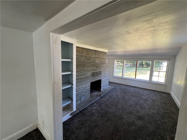 unfurnished living room with a large fireplace, carpet, vaulted ceiling, and built in features