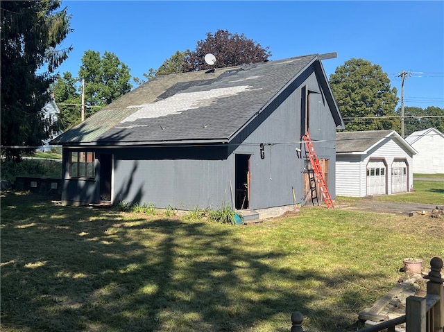 view of side of home featuring an outdoor structure, a garage, and a yard