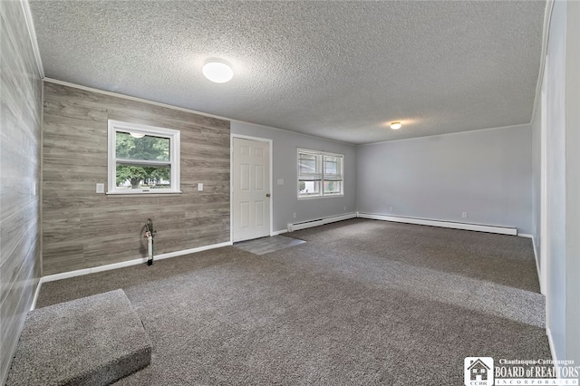 interior space with a textured ceiling, wood walls, and a baseboard radiator