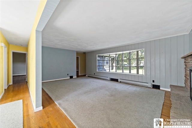 unfurnished living room with light hardwood / wood-style floors, a fireplace, and a baseboard radiator