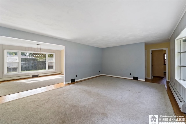 unfurnished living room with dark carpet and baseboard heating