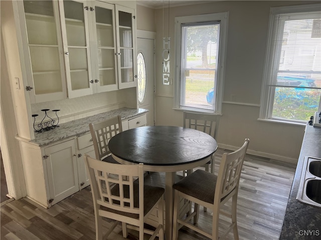 dining space with dark hardwood / wood-style flooring and a healthy amount of sunlight