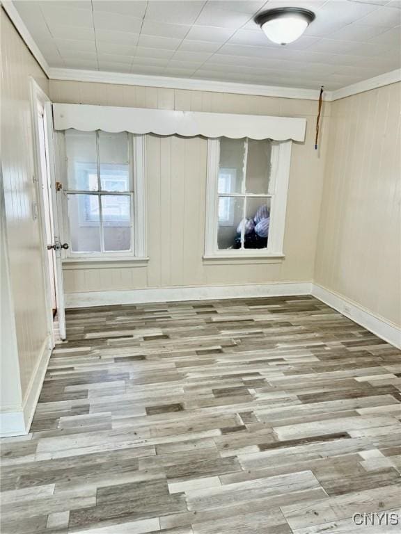 unfurnished room with wood-type flooring and crown molding