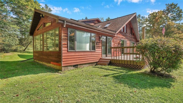 view of property exterior with a deck and a yard