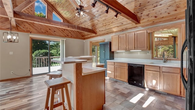 kitchen with pendant lighting, ceiling fan with notable chandelier, a kitchen bar, black appliances, and light brown cabinets