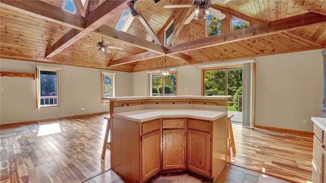 kitchen featuring light wood-type flooring, decorative light fixtures, ceiling fan, and wooden ceiling