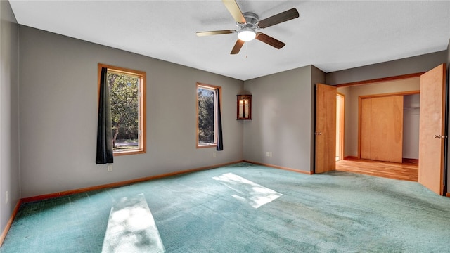 carpeted spare room featuring ceiling fan