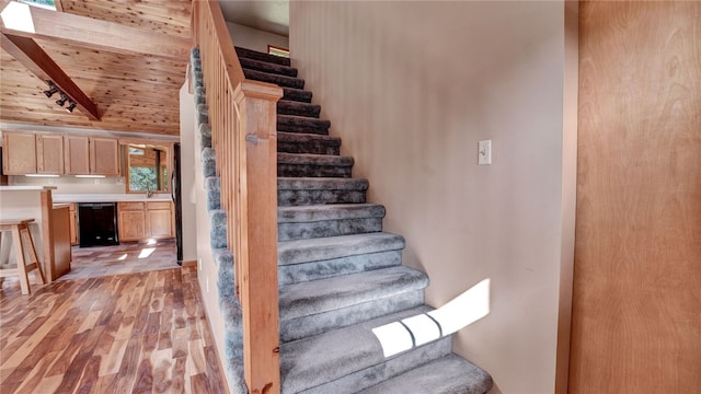 staircase featuring vaulted ceiling with beams, hardwood / wood-style flooring, and wooden ceiling