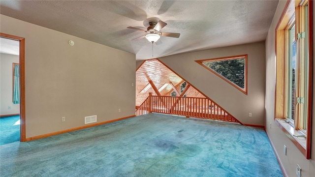 carpeted spare room featuring ceiling fan and a textured ceiling