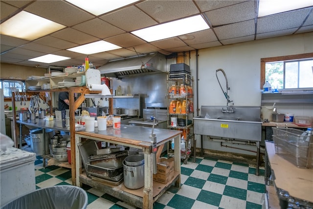 interior space featuring tile patterned floors, a drop ceiling, and a sink