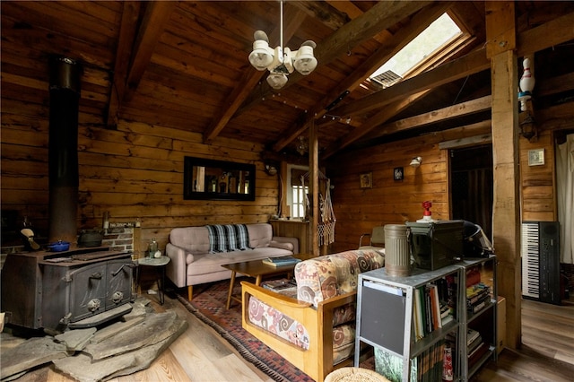 living room featuring wood walls, a wood stove, hardwood / wood-style flooring, lofted ceiling with skylight, and wooden ceiling