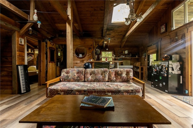 living room featuring ceiling fan, wood walls, light hardwood / wood-style floors, and wooden ceiling