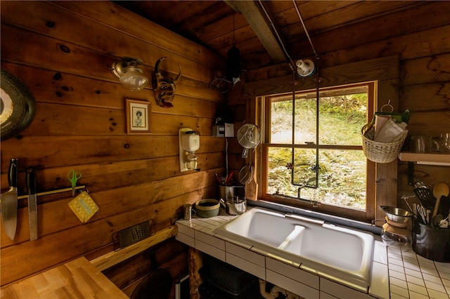 bathroom with wooden walls, beam ceiling, wooden ceiling, and a healthy amount of sunlight