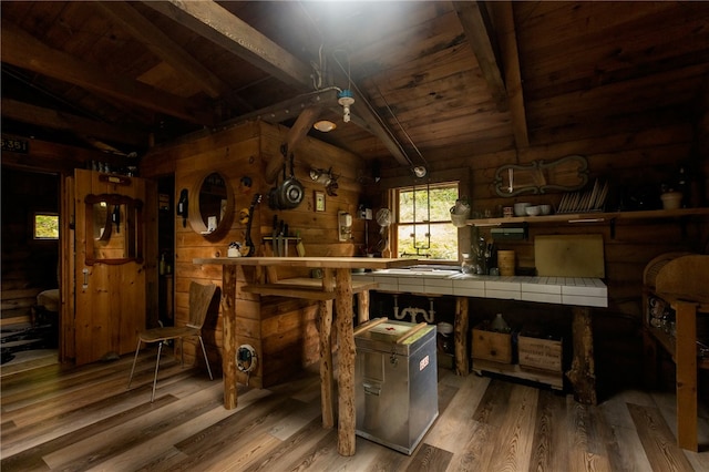 interior space with vaulted ceiling with beams, wood ceiling, wooden walls, and hardwood / wood-style flooring