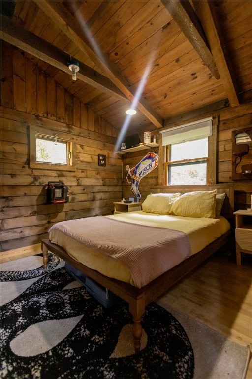 bedroom with vaulted ceiling with beams, hardwood / wood-style flooring, wooden walls, and multiple windows