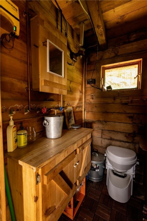 bathroom featuring wooden ceiling, wooden walls, and toilet