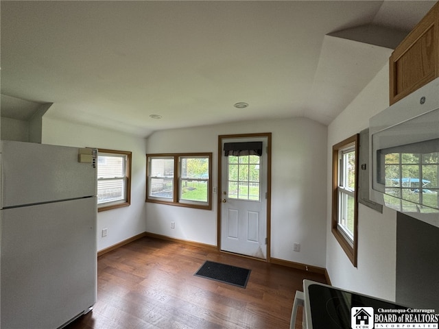 doorway to outside featuring lofted ceiling, a healthy amount of sunlight, baseboards, and wood finished floors