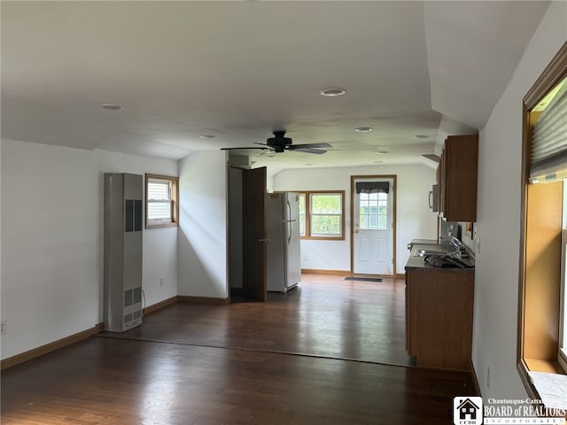 interior space featuring ceiling fan, dark wood-type flooring, a sink, and baseboards