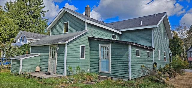 rear view of property featuring a chimney